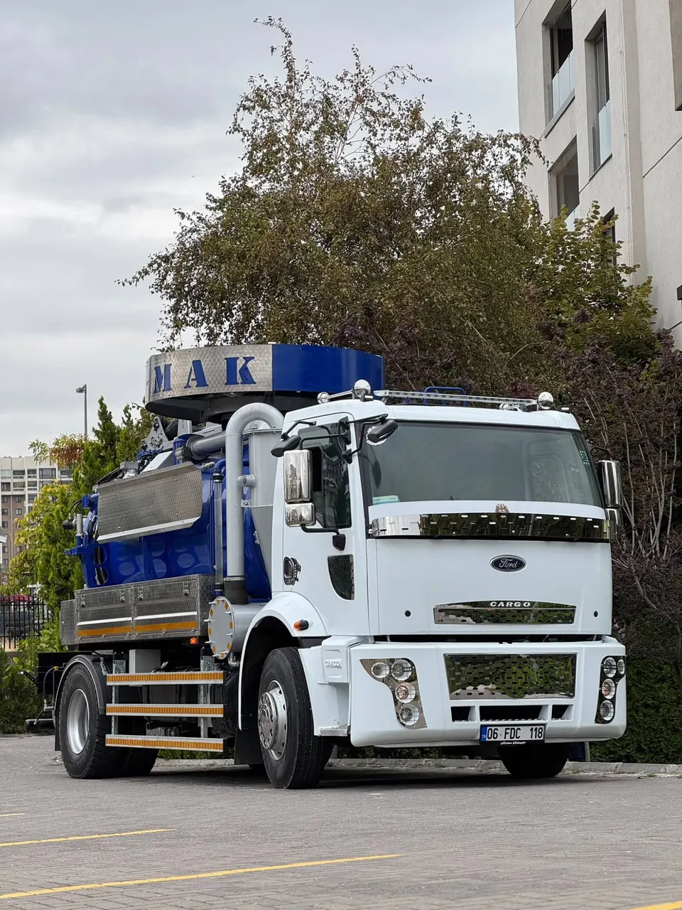 Arslan Vidanjör'ün beyaz kabinli, mavi tanklı vidanjör aracı bir konut sitesinin önünde