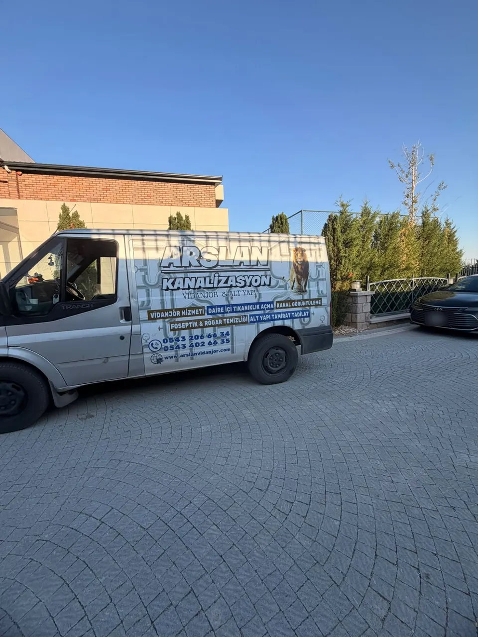 Taş döşeli bir villa girişinde park etmiş Arslan servis aracı